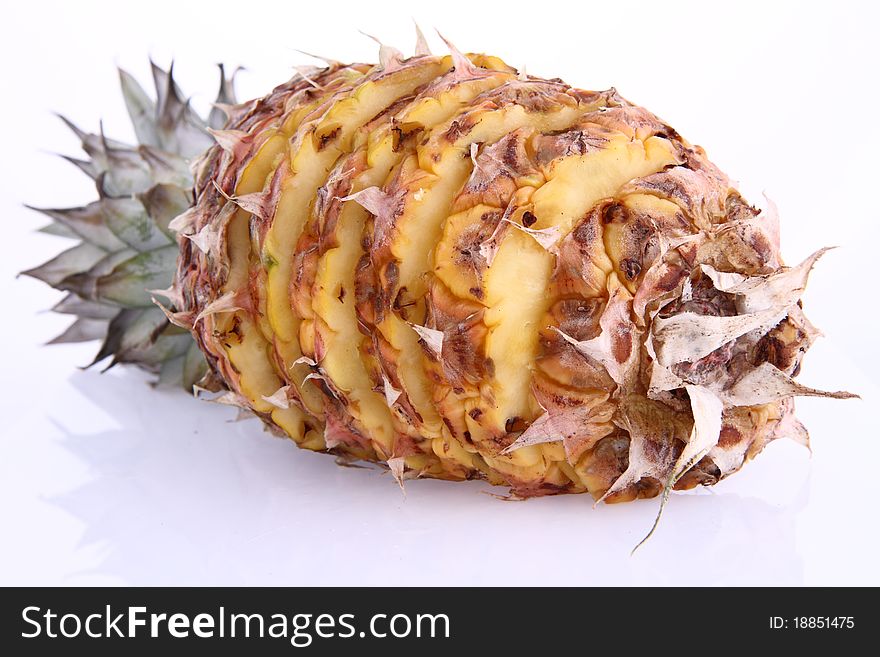 Pineapple - partially cut into slices, on white background