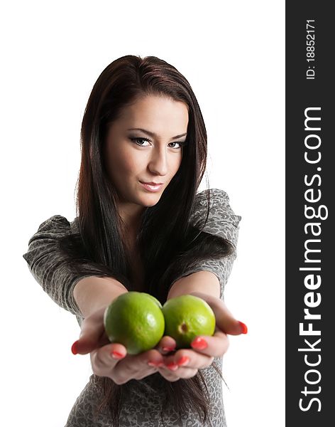 Young woman holding and giving away limes isolated on white