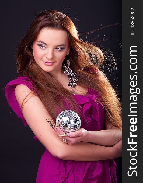 Beautiful long-haired brunette in a dress of fuchsia and a disco ball. Beautiful long-haired brunette in a dress of fuchsia and a disco ball