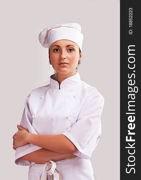 Young woman in white chef dress with hat. Young woman in white chef dress with hat