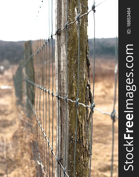 Wooden fence with metal netbarbed wire