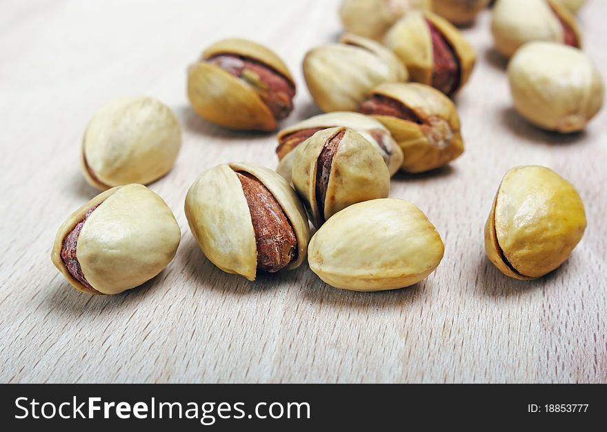 Beautiful pistachio seeds on wood close up