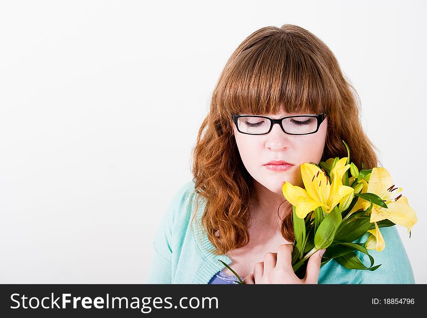 Beautiful teen in glasses holding yellow flowers, isolated on white. Beautiful teen in glasses holding yellow flowers, isolated on white.