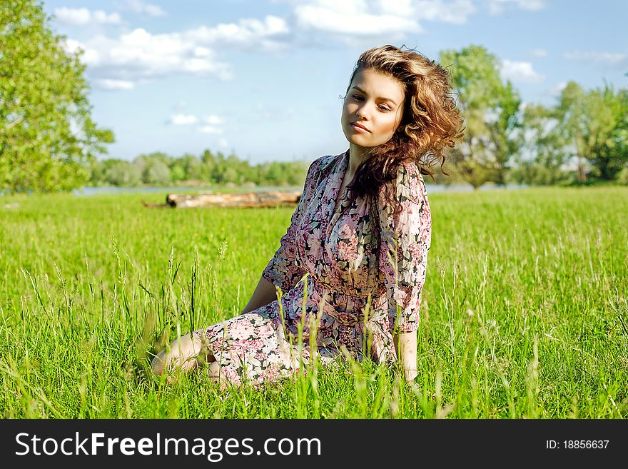 Relaxed  girl sitting on grass in park - Outdoor