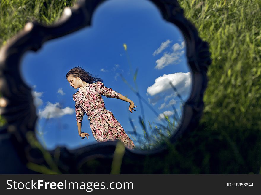 Girl Stands On Background Sky Reflected In Mirror