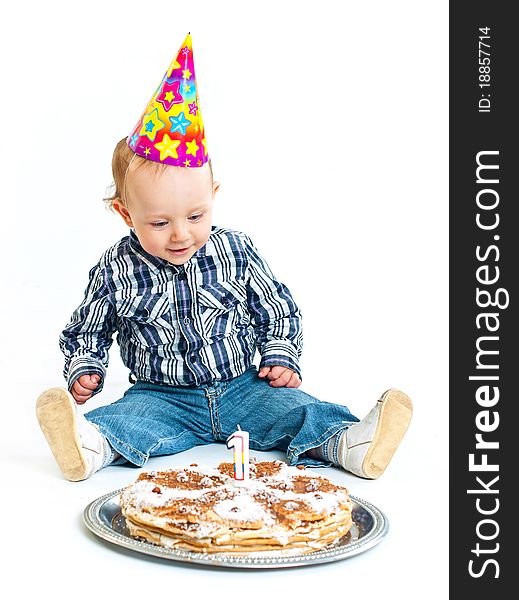 First birthday. Cute little boy in a cap with a birthday cake and a candle