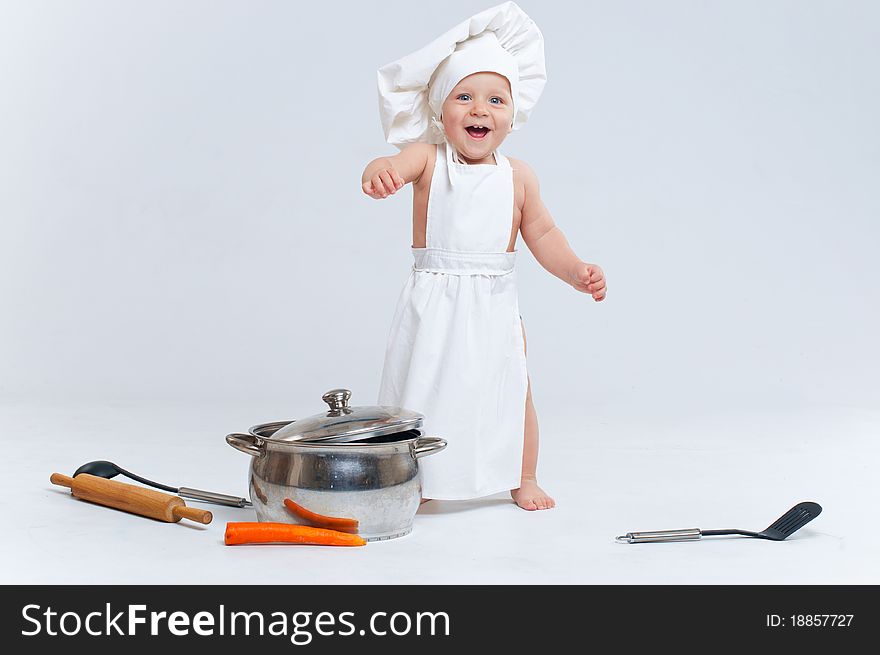 Little cook. Cute little boy in a suit of Food Boy with kitchen accessories. In the studio