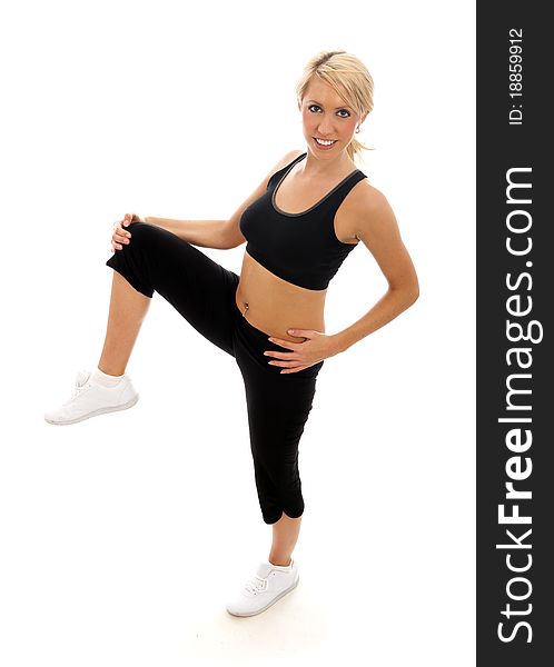 A female dressed in gym clothes performing a leg stretch. A female dressed in gym clothes performing a leg stretch