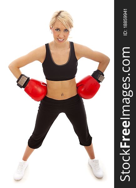 A female wearing red boxing gloves with herand on her hips. A female wearing red boxing gloves with herand on her hips