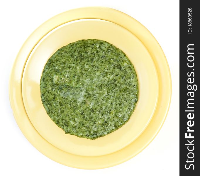 Spinach cream soup in yellow plate