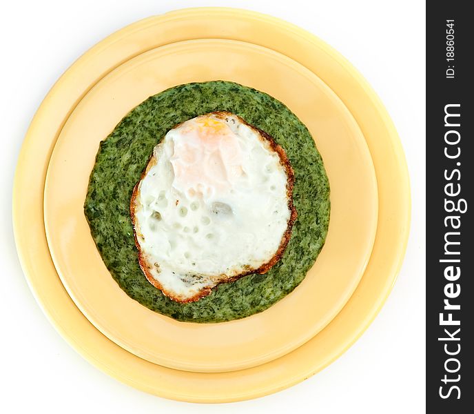 Spinach cream soup with egg in yellow plate