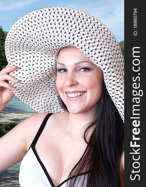 The young smiling girl in a hat at the river. The young smiling girl in a hat at the river