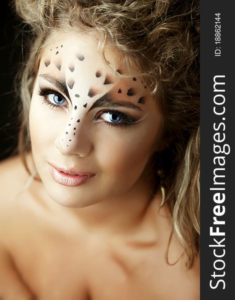 The image of a beautiful girl with an unusual make-up as a leopard