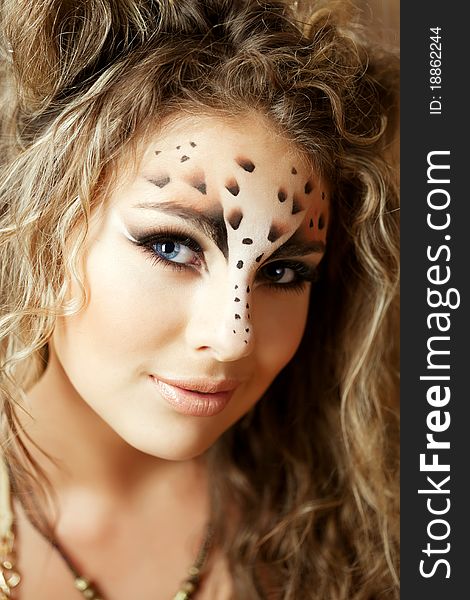 The image of a beautiful girl with an unusual make-up as a leopard