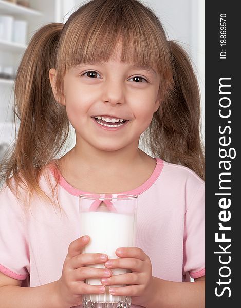 Cute little girl and glass of milk in kitchen. Cute little girl and glass of milk in kitchen