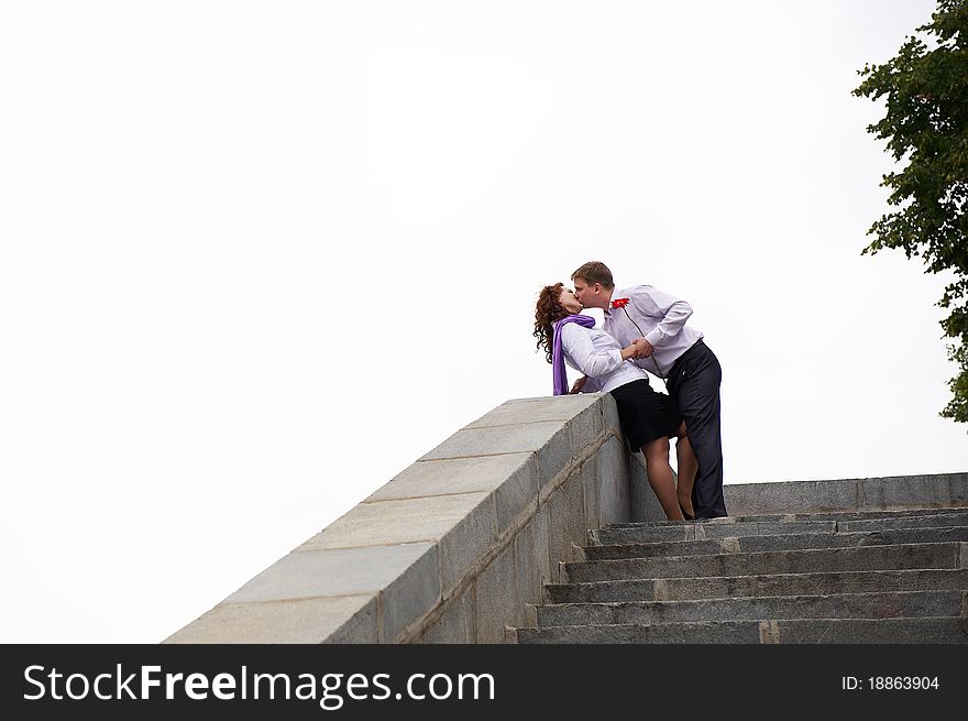 Romantic kiss on the stone stairs on white background