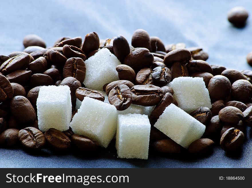 Close-up of roasted coffee beans and sugar. Close-up of roasted coffee beans and sugar.