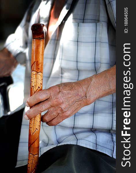 Elderly hand holding a cane. Elderly hand holding a cane