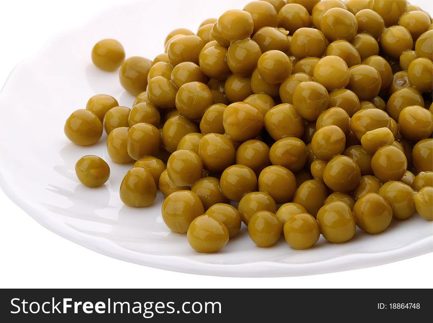 Canned green peas on a white plate. Series of canned foods