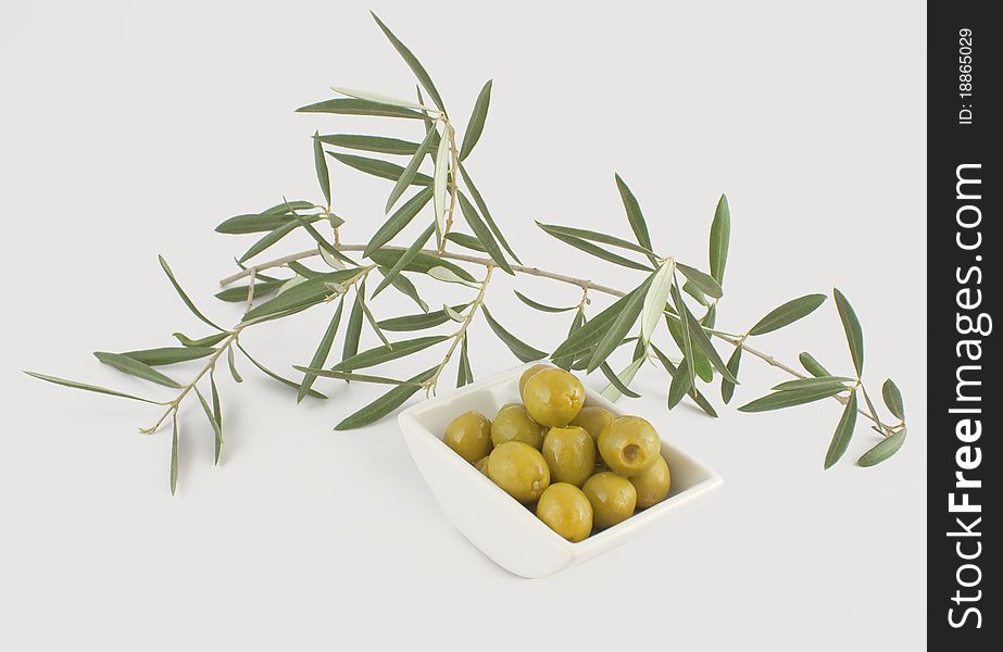 Olives with a branch of an olive tree on a white background