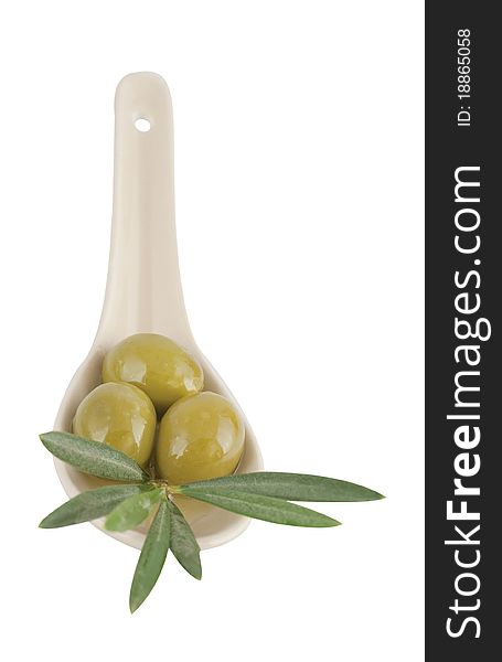 Olives in a spoon with leaves on a white background
