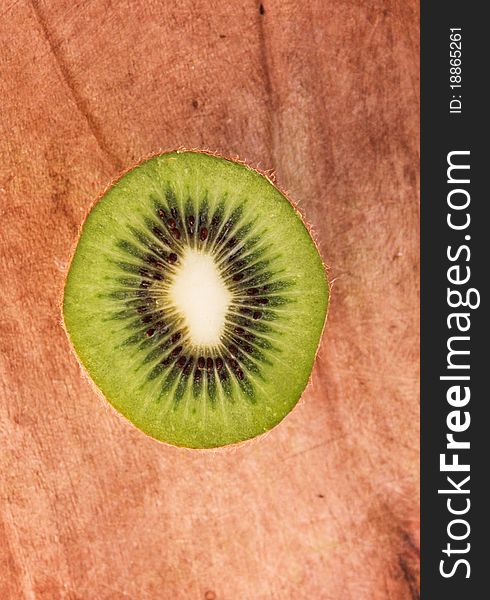 Half of the kiwi on a wooden board