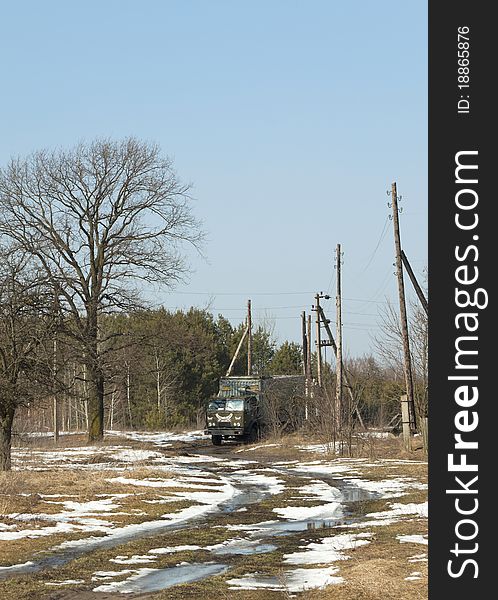 The lorry goes in the spring on a country road near wood. The lorry goes in the spring on a country road near wood