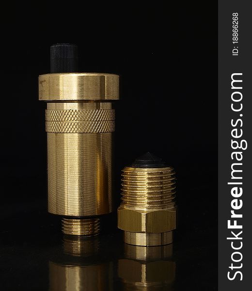 Golden brass desaerator and automatic valve over black background