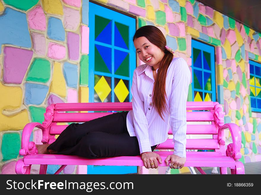 Asian young women sitting on pink chair and smile