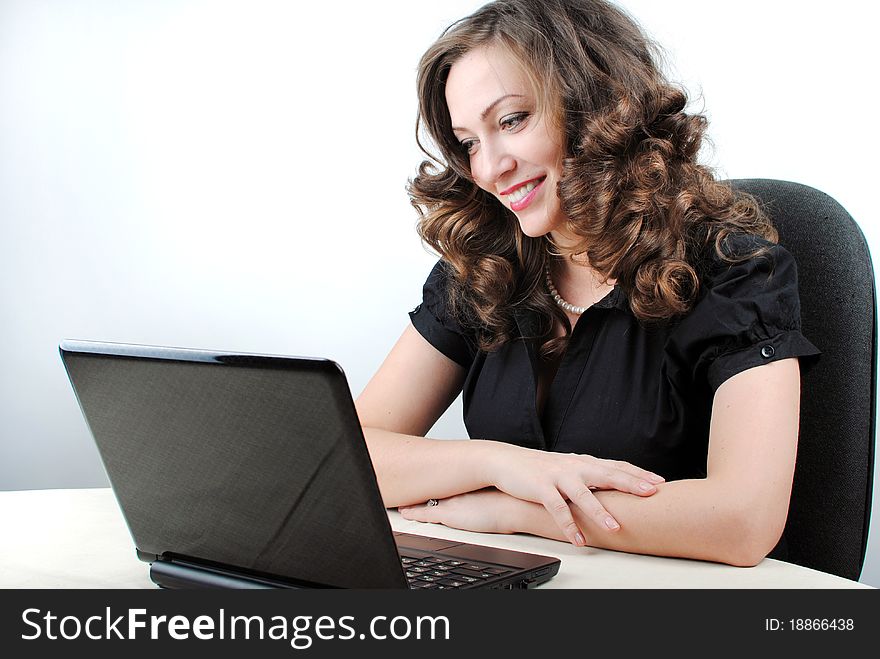 Young successful woman working at desk with laptop