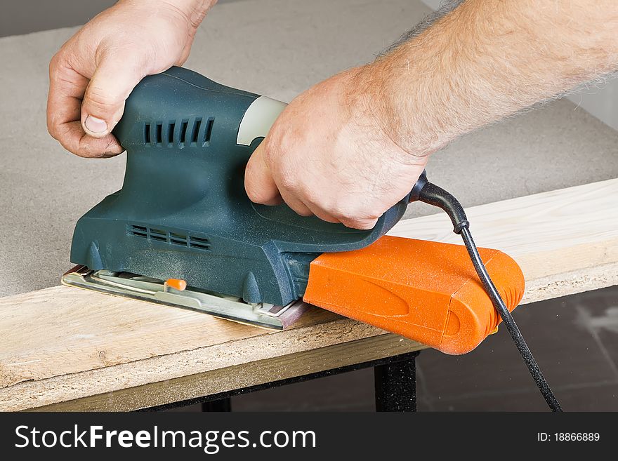 A man working with electrical sanding machine, close up on tool, hands and sparks, real situation picture. A man working with electrical sanding machine, close up on tool, hands and sparks, real situation picture