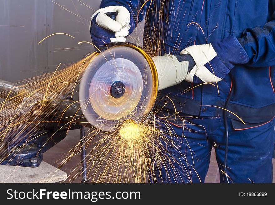 A man working with grinder, close up on tool, hands and sparks, real situation picture. A man working with grinder, close up on tool, hands and sparks, real situation picture
