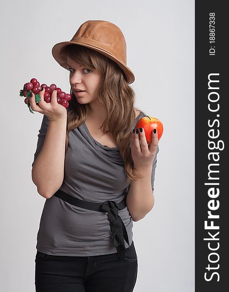 Girl with grapes and apples in the hands of