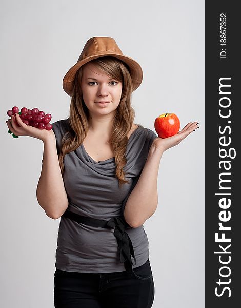 Girl on a white background with grapes and apples in the hands of. Girl on a white background with grapes and apples in the hands of