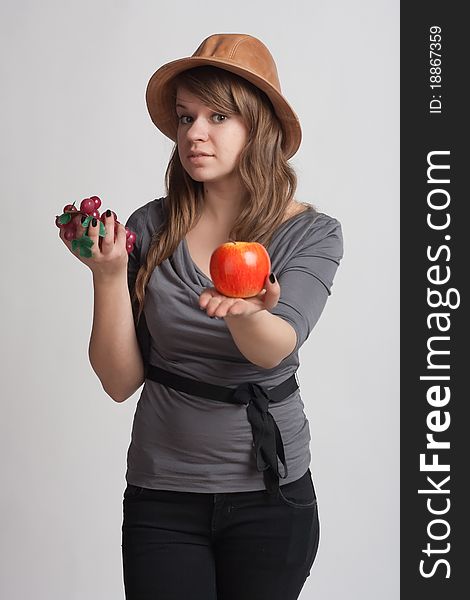 Girl on a white background with grapes and apples in the hands of. Girl on a white background with grapes and apples in the hands of