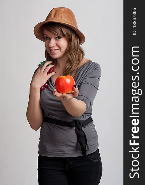 Girl on a light background offers apple. Girl on a light background offers apple