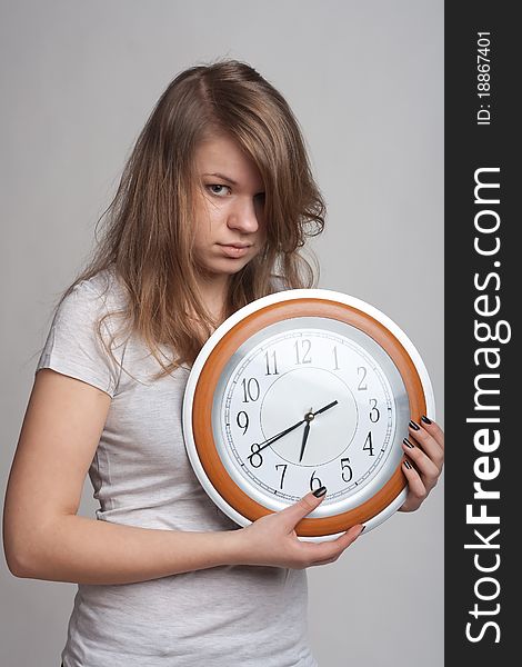 Sleeping girl on a white background with a big clock in the hands of which 6.40 am. Sleeping girl on a white background with a big clock in the hands of which 6.40 am