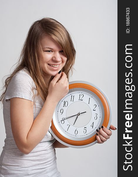 Beautiful girl with a big clock in his hands