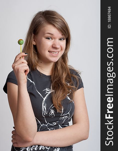 Girl on a white background with candy on a stick in his hand. Girl on a white background with candy on a stick in his hand