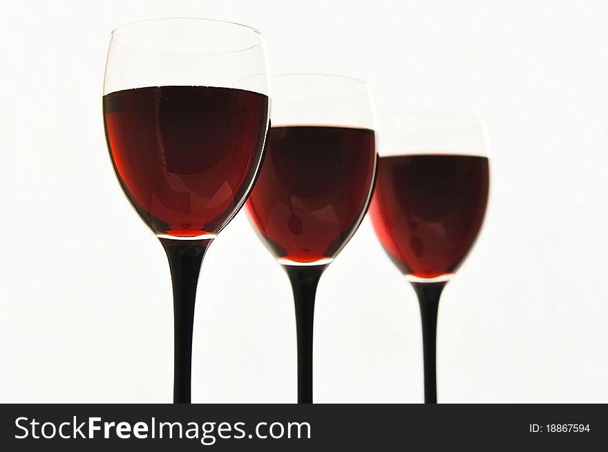 Red wine in glass glasses on the white isolated background