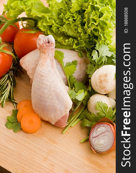 Photo of wooden chopping board with chicken and vegetables. Photo of wooden chopping board with chicken and vegetables