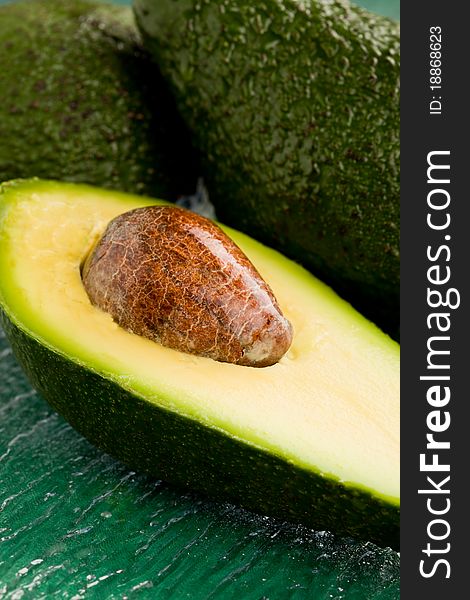 Photo of cutted avocado fruit on green glass table