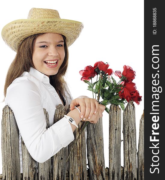 A happy young teen holding a bouquet of red flowers by an old, weathered fence. A happy young teen holding a bouquet of red flowers by an old, weathered fence.