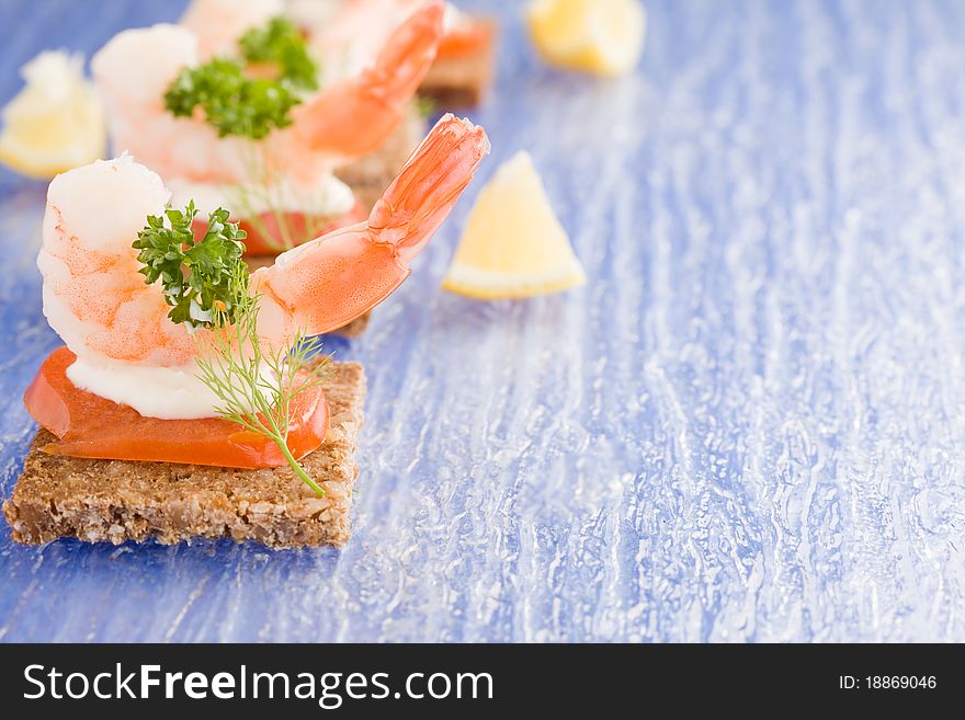 Photo of delicious starter made of prawns and tomatoes on black bread. Photo of delicious starter made of prawns and tomatoes on black bread