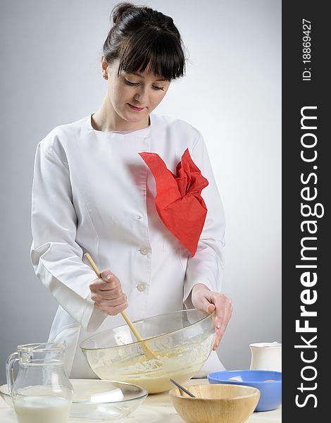 White young chef preparing dough and mixing milk with flour. White young chef preparing dough and mixing milk with flour