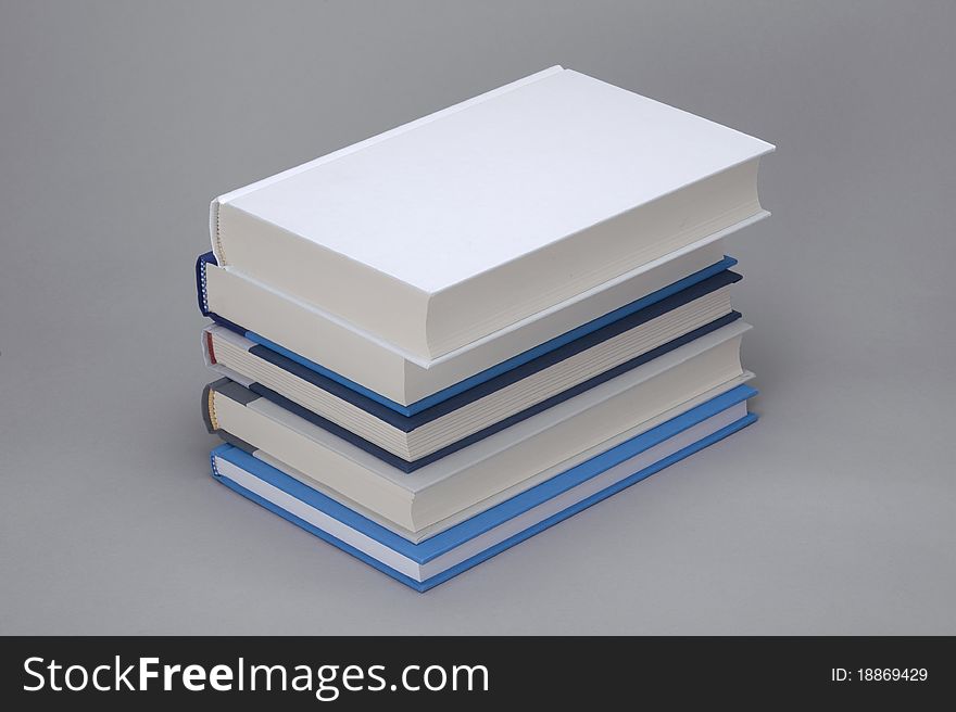 A bunch of 5 books with white plain book on the top. A bunch of 5 books with white plain book on the top