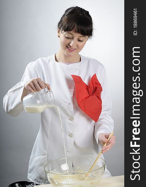 White young chef preparing dough and mixing milk with flour. White young chef preparing dough and mixing milk with flour