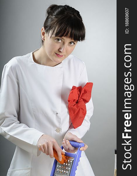 White woman working with carrot with metalic grater. White woman working with carrot with metalic grater