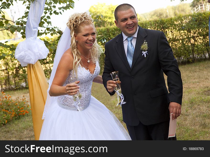 Bride and groom with champagne glasses smiling. Bride and groom with champagne glasses smiling