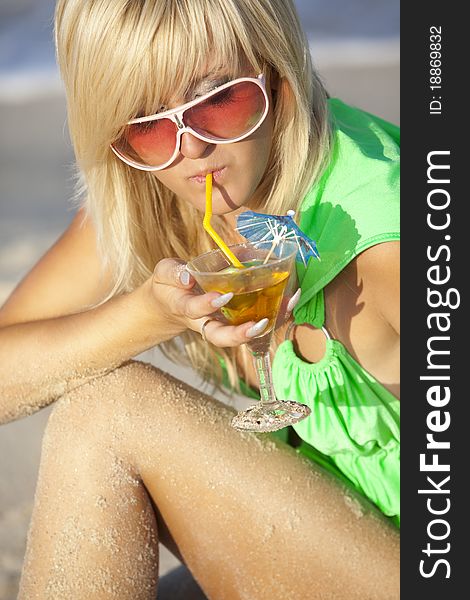 A beautiful girl at the sunny beach with martini glass. A beautiful girl at the sunny beach with martini glass